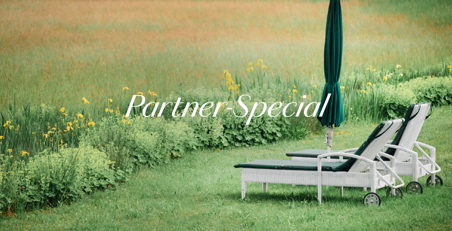 Zwei Liegen laden zum gemeinsamen Entspannen im Grünen ein.