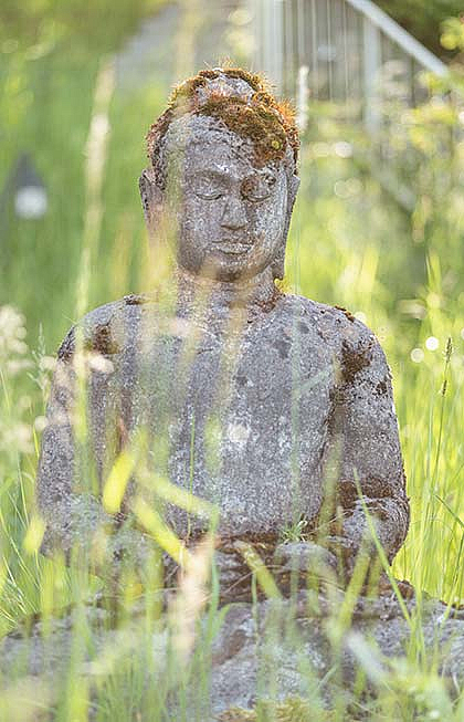 Ein Buddha aus Stein bewacht das Seehaus.