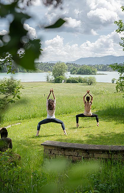 Yoga in freier Natur mit Blick über See und Berge.