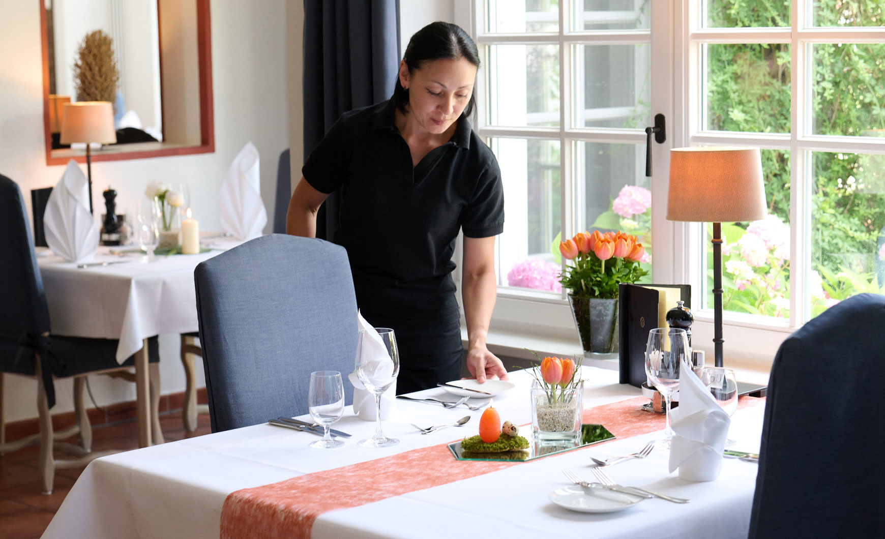 Das Restaurant wird zu Ostern mit unzähligen orange leuchtenden Tulpen und Kerzen geschmückt.