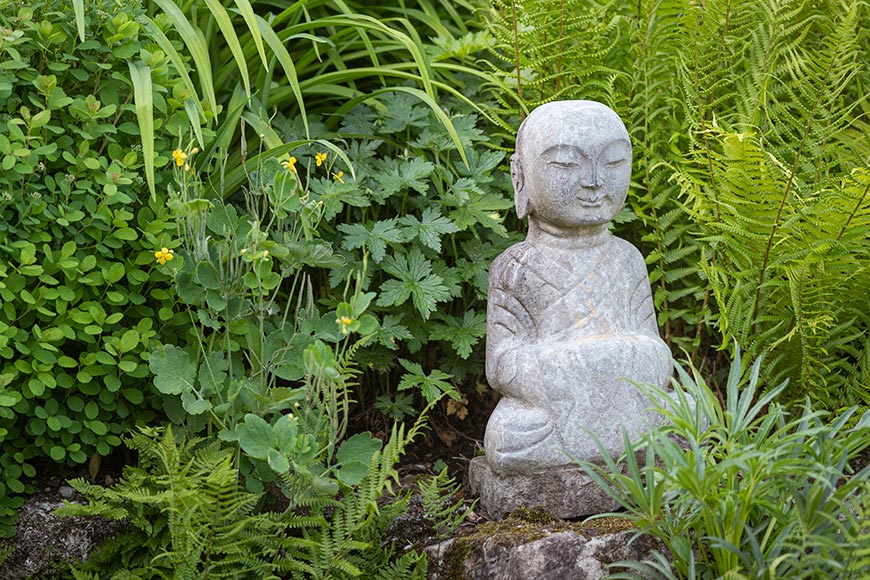 Buddhafiguren im Garten am Teich.