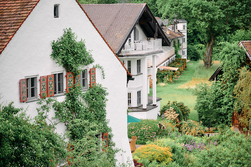 Gebäude aus drei Jahrhunderten, umgeben von üppiger Natur.