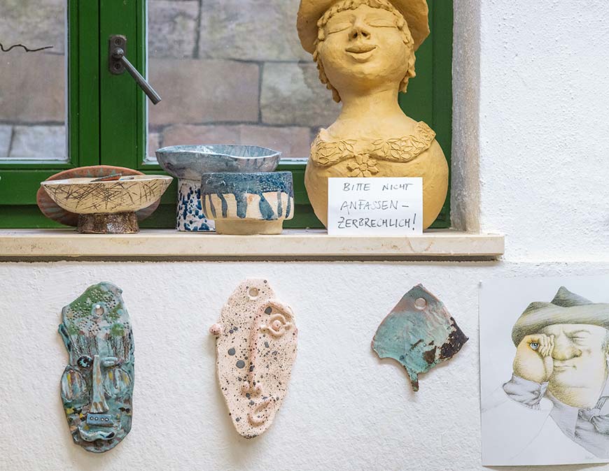 Masken und zerbrechliche Figuren in der Keramikwerkstatt.